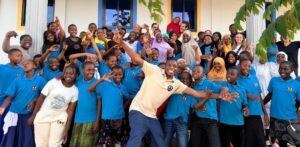 Silver Birch Care team with children in blue uniforms outside the Shabaha Children's Home, Tanzania